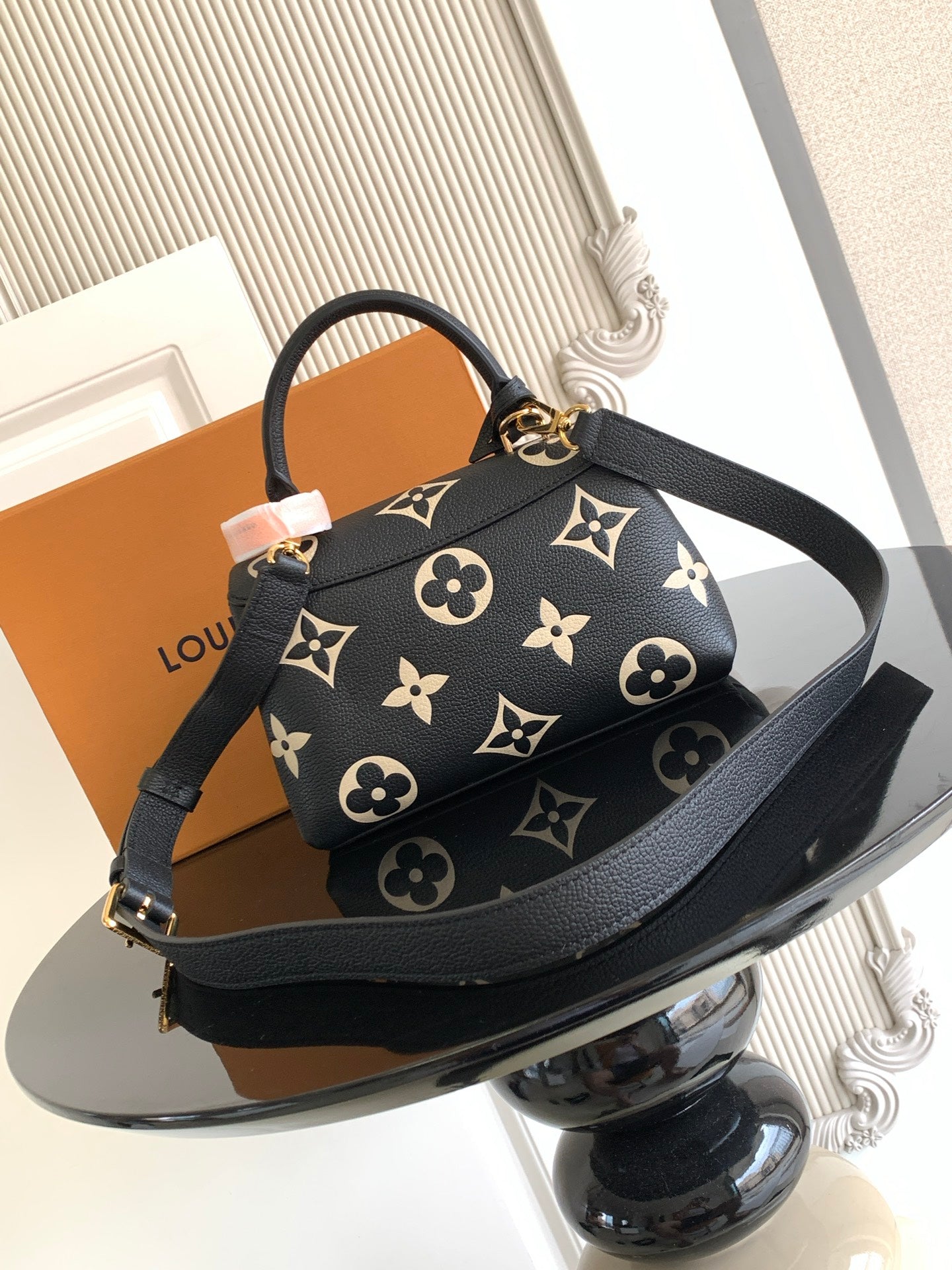 Louis Vuitton monogram mini bag with shoulder strap and gold clasp, black with tan motifs