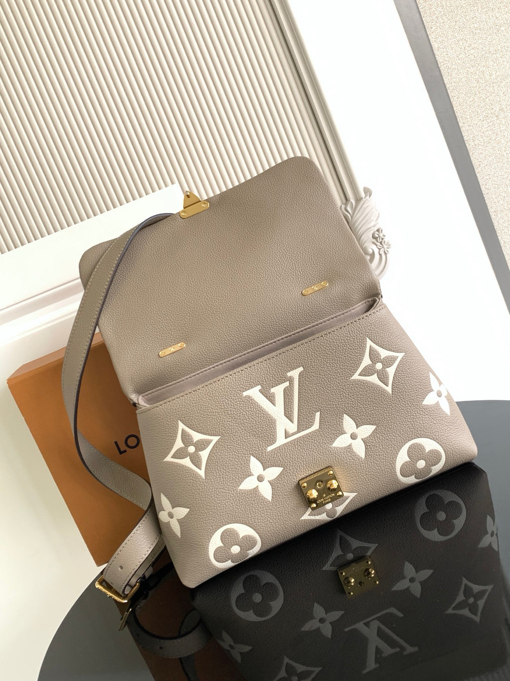 Beige Louis Vuitton crossbody bag with monogram print and gold turn-lock clasp
