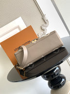 Beige Louis Vuitton long flap bag with gold clasp and adjustable shoulder strap