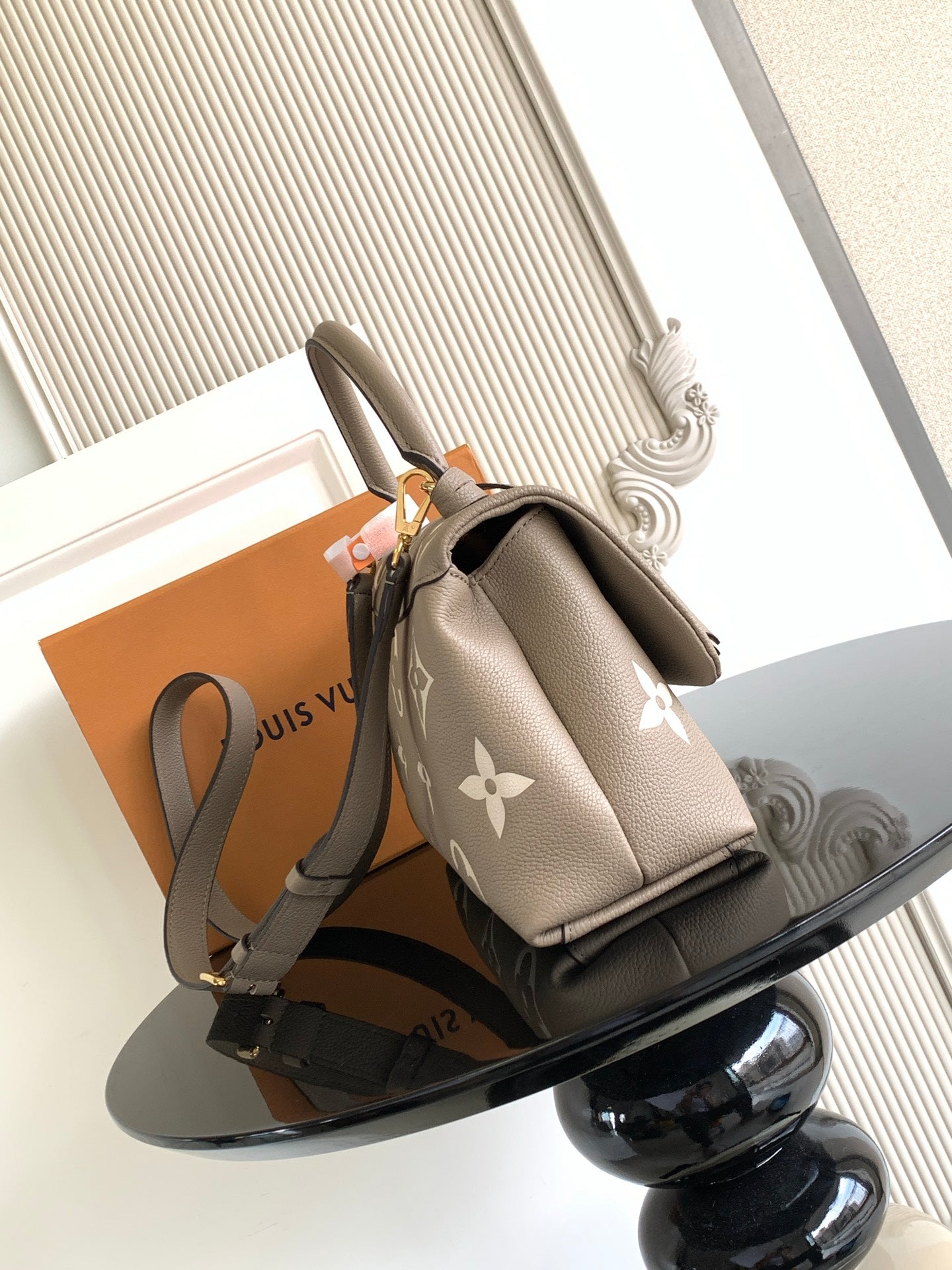 Beige Louis Vuitton mini bag with monogram print, top handle, and shoulder strap