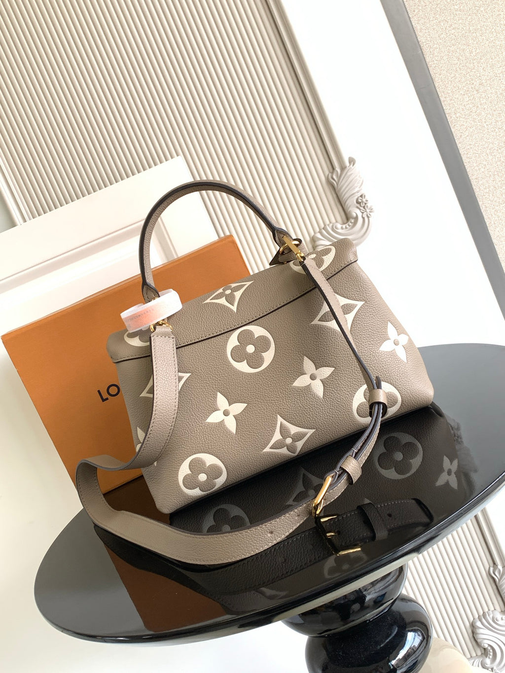 Beige Louis Vuitton tote-style bag with monogram print and gold turn-lock clasp