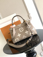 Beige Louis Vuitton tote-style bag with monogram print and gold turn-lock clasp