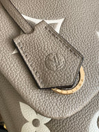 Beige Louis Vuitton logo embossing on monogram bag with gold keyring detail