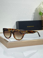 Balenciaga sunglasses with tortoiseshell frame and dark lenses, gold BB emblem on bridge
