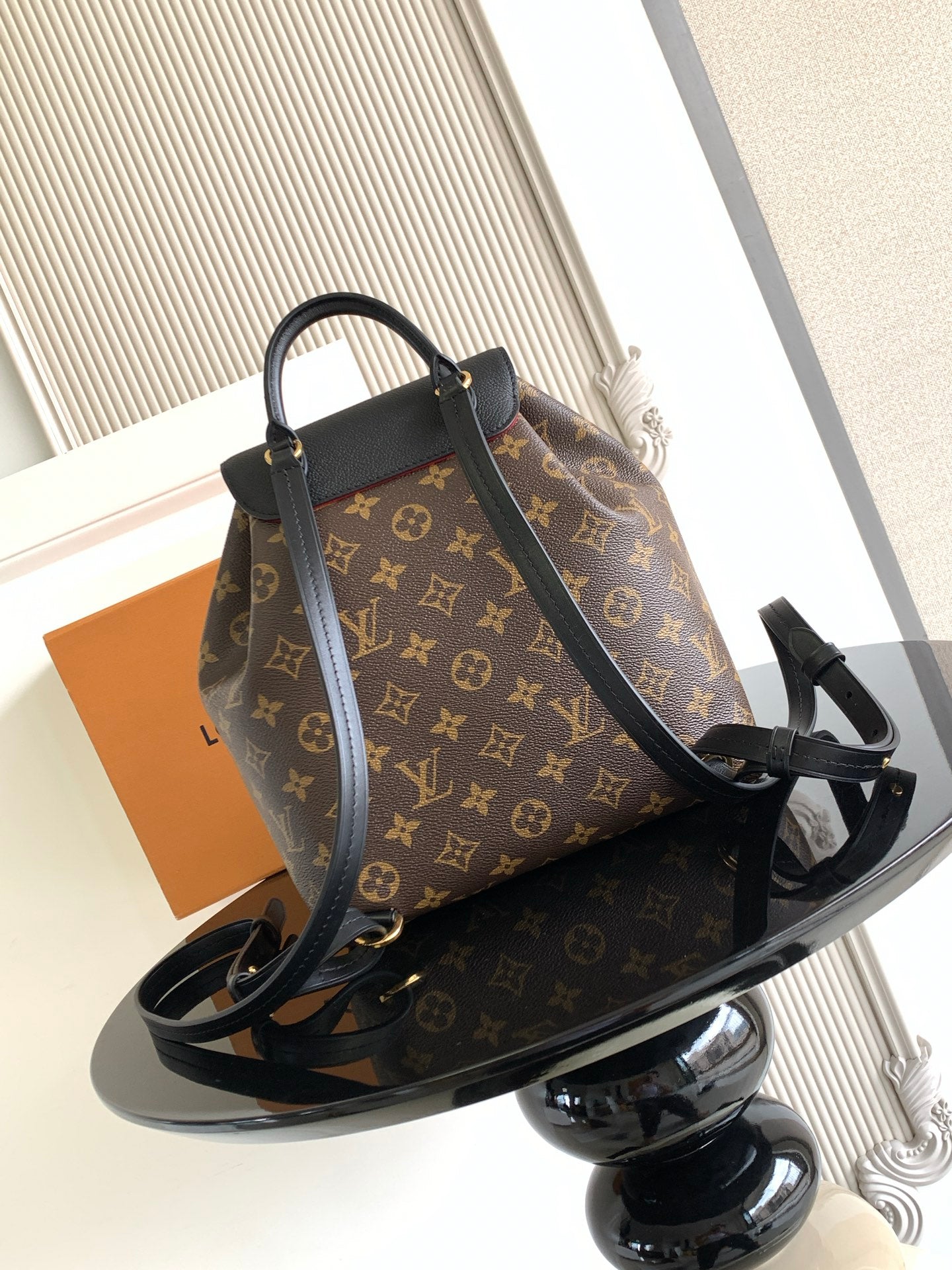 Louis Vuitton monogram bag with black crossbody strap and front clasp hardware