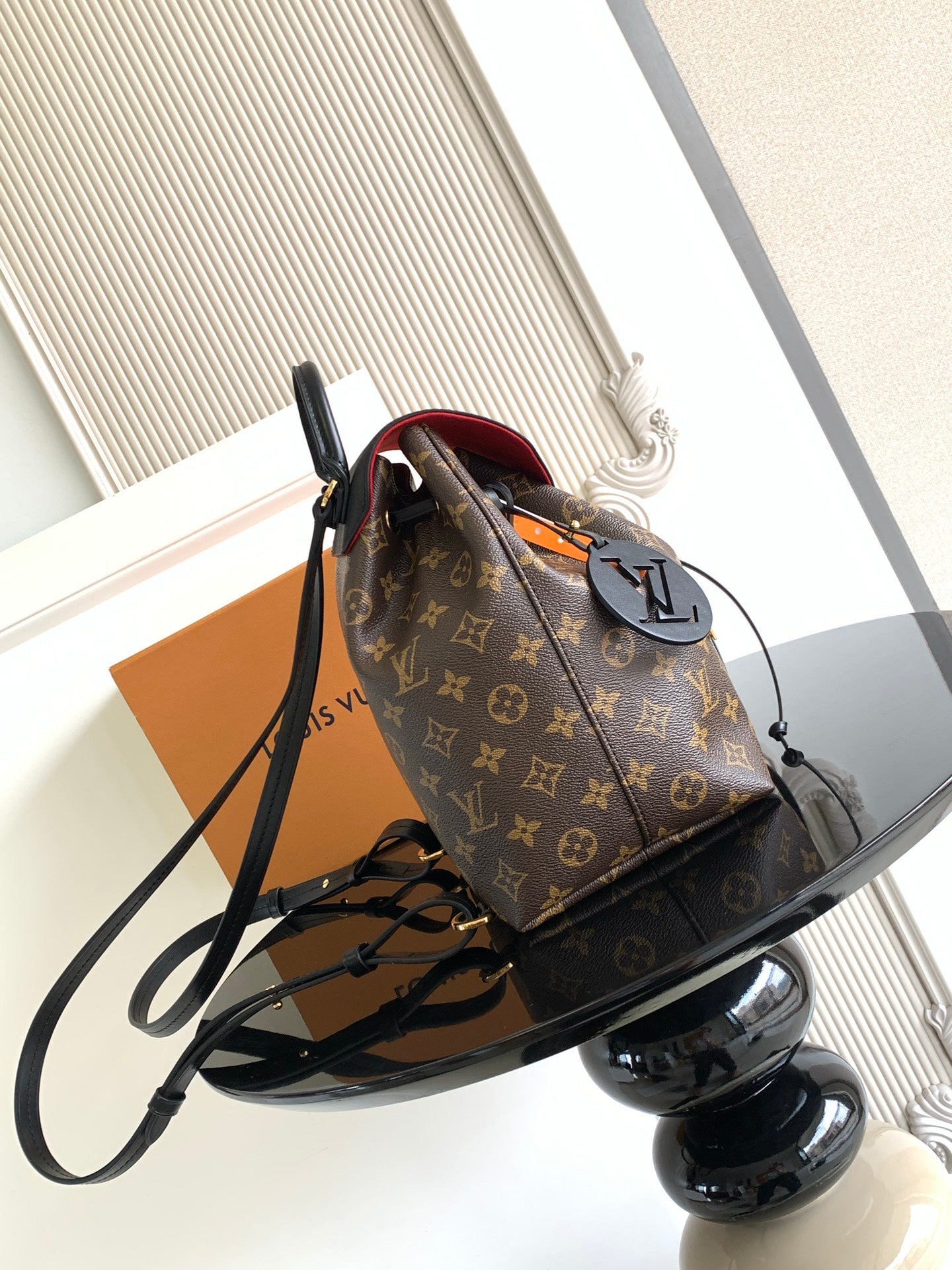 Louis Vuitton monogram bag with black shoulder strap and top zipper closure