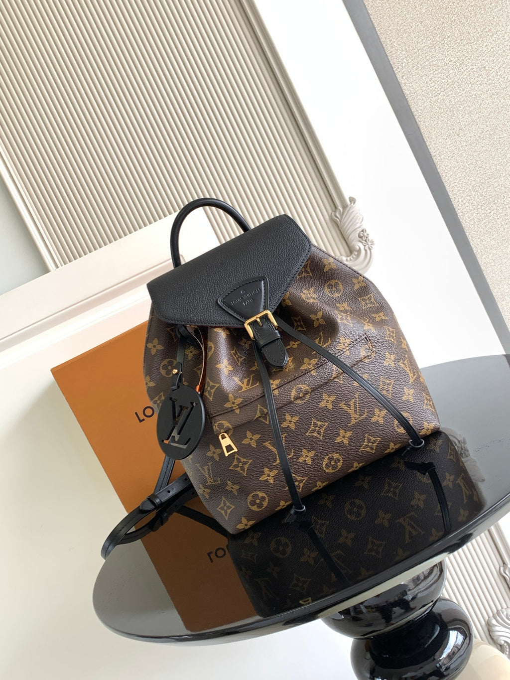 Louis Vuitton monogram bag with black top handle and front lock details