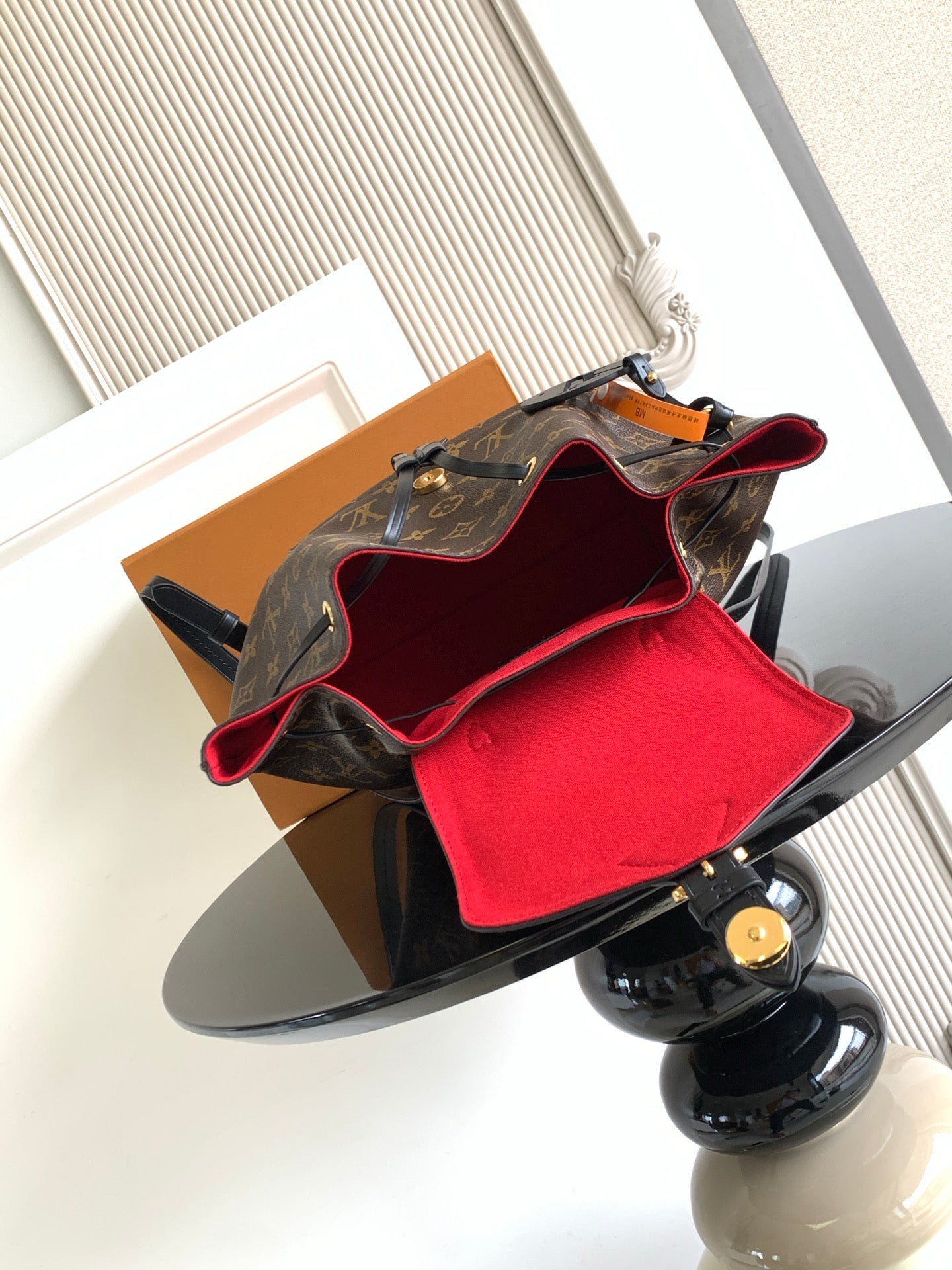 Louis Vuitton monogram bag open with red lining interior pouch visible