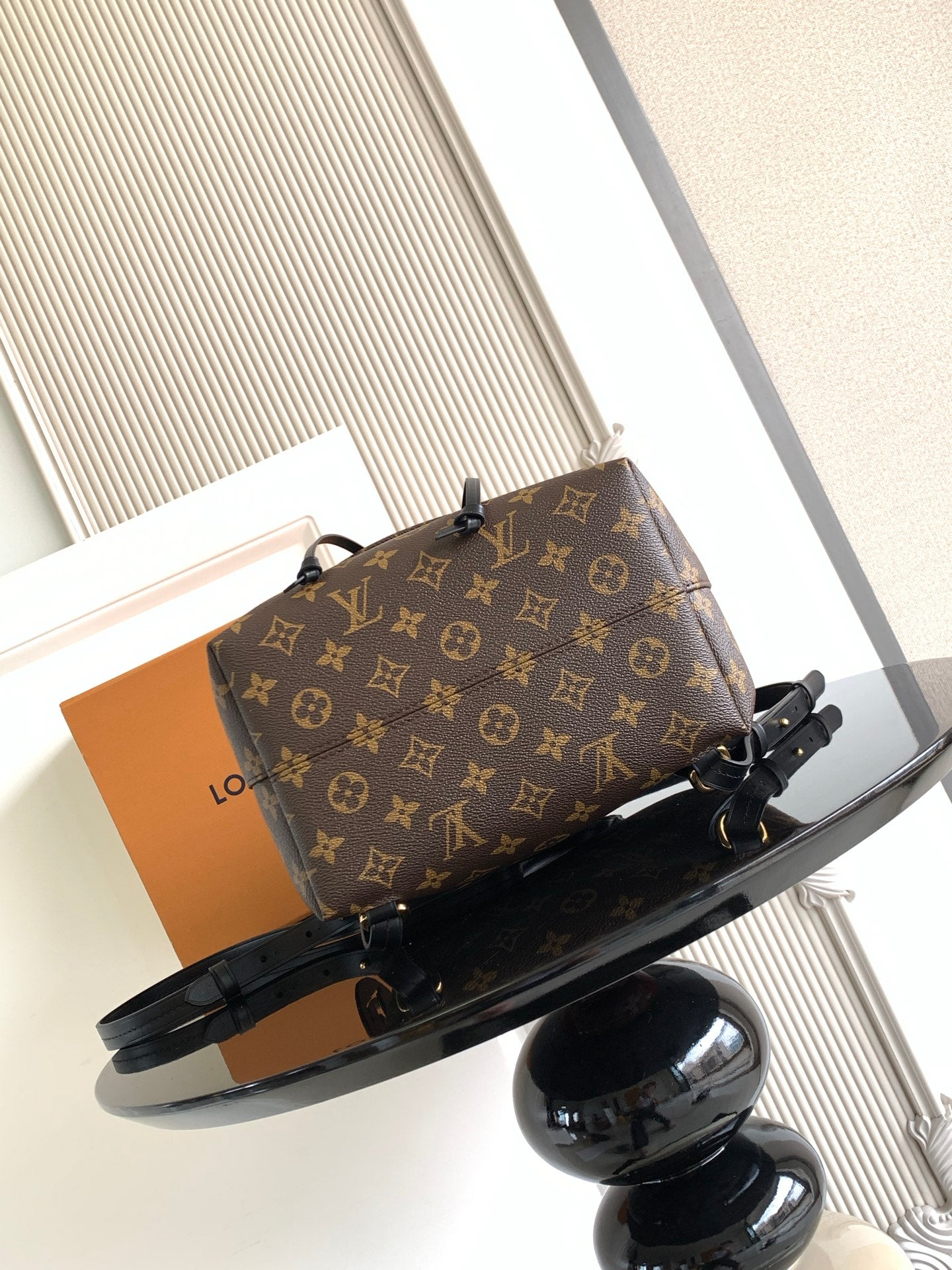 Louis Vuitton monogram bag angled view with black straps and tag detail