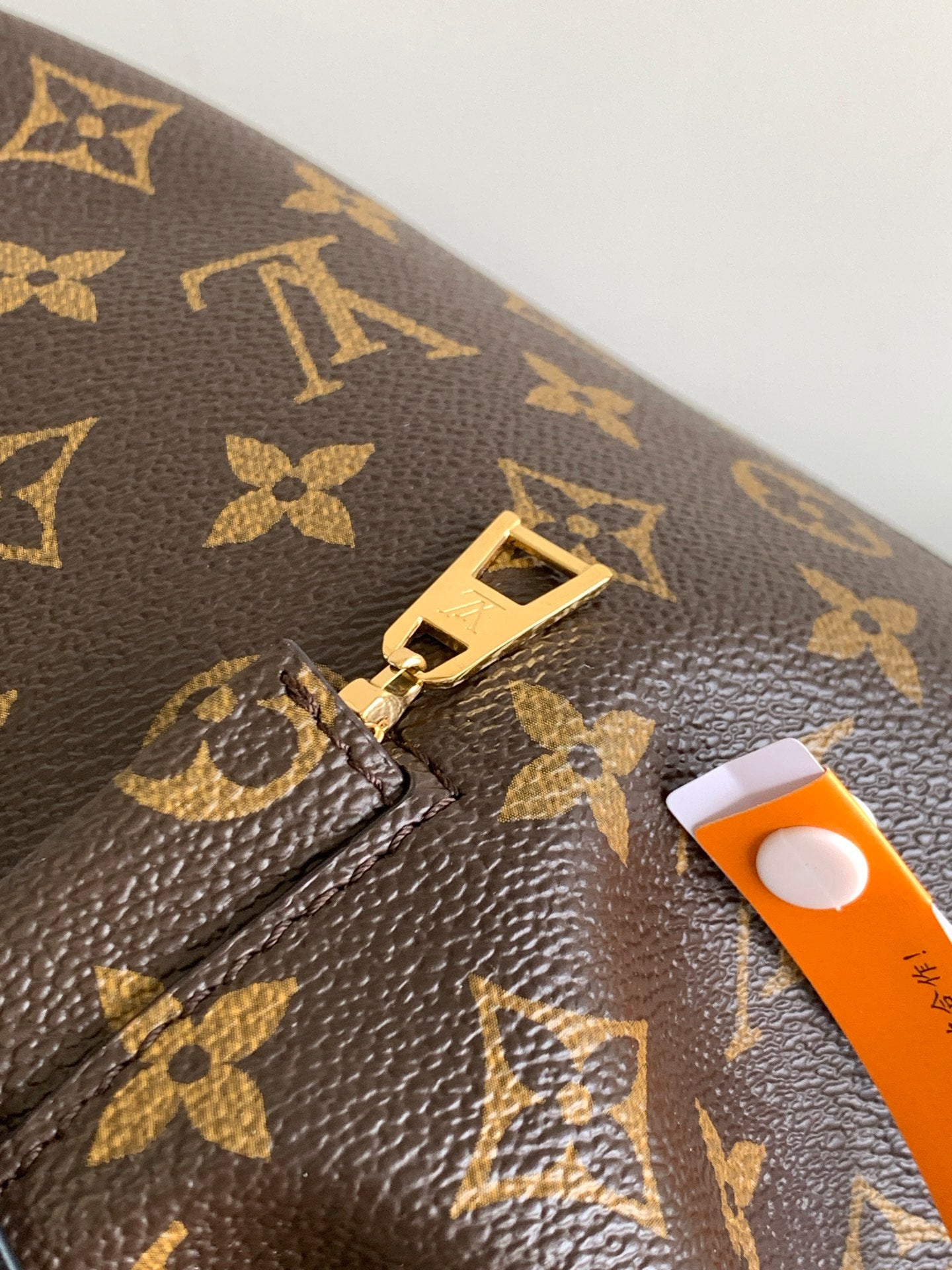 Louis Vuitton monogram bag close-up of gold lock hardware on monogram canvas