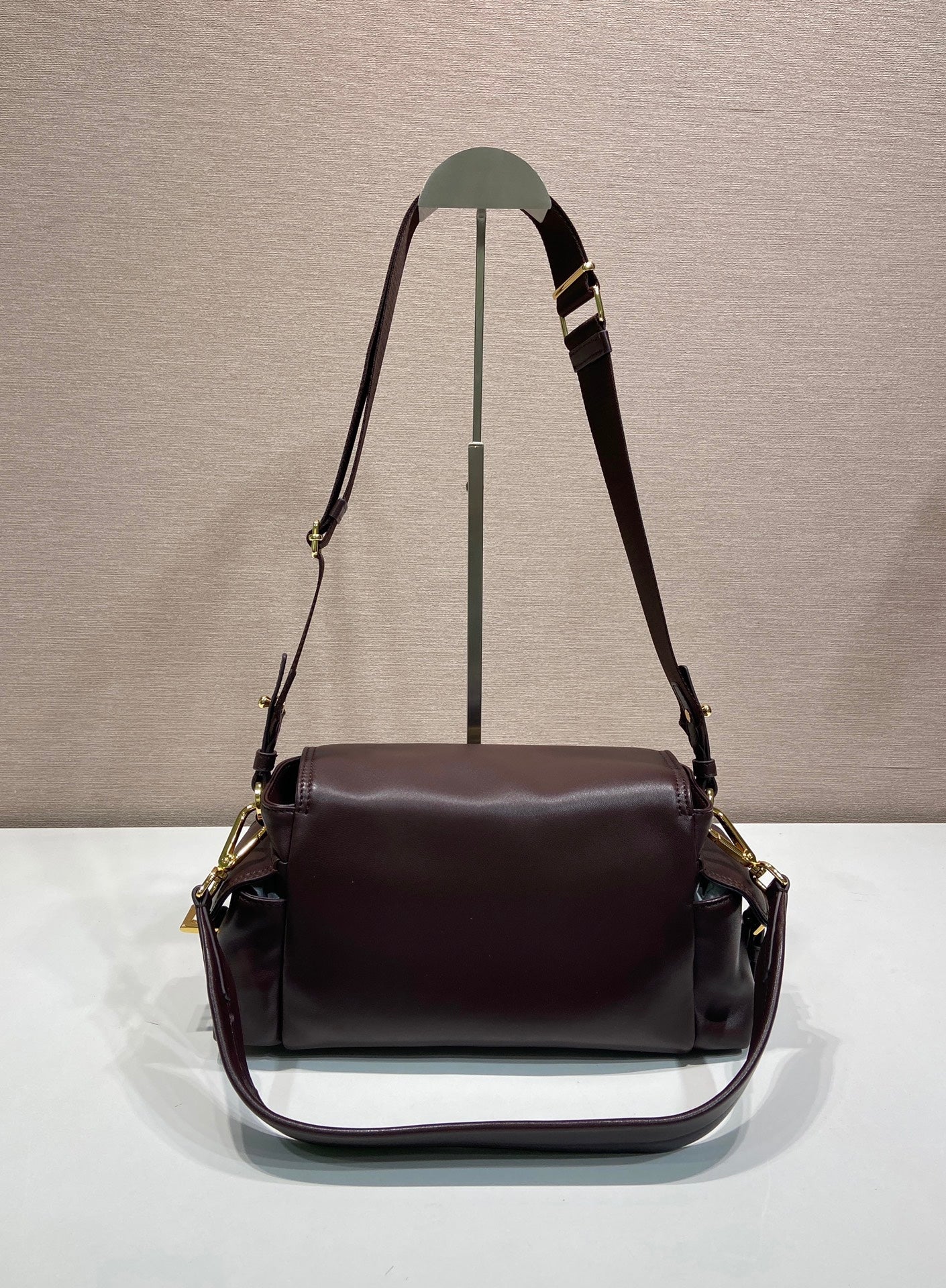 Prada leather shoulder bag with long straps and front flap, dark brown.