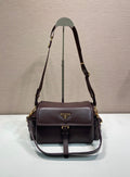 Prada leather shoulder bag with flap and gold-tone hardware, dark brown.