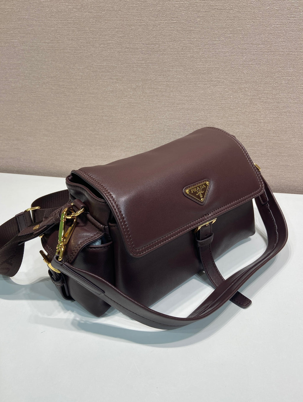 Prada leather shoulder bag with structured top flap, dark brown.