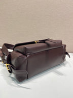 Prada leather bag with top handle and side straps, dark brown.