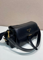 Prada black leather shoulder bag with curved flap, gold zipper pull, and side stitching.