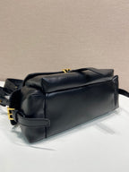 Prada black leather bag with top flap, stitched seams, and gold hardware.