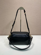 Prada black leather shoulder bag with top handle, long strap, and gold hardware.