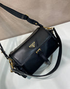 Prada black leather shoulder bag with logo plaque, flap closure, and gold chain strap.