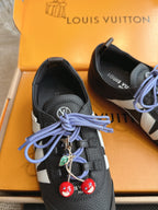Louis Vuitton unisex sneakers detail: black leather, blue laces, red and green charms
