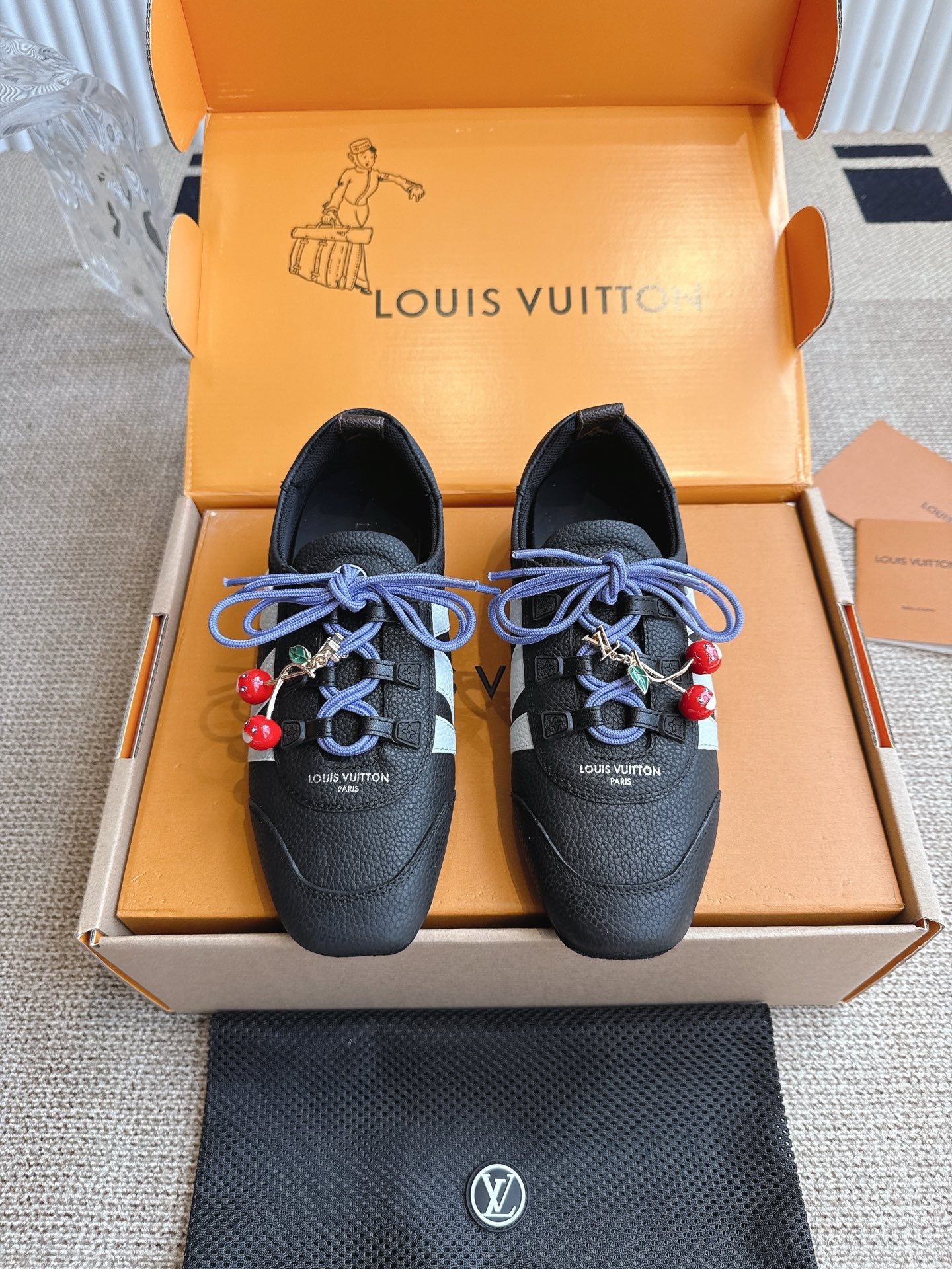 Louis Vuitton unisex leather sneakers in dark black with blue laces and red charm