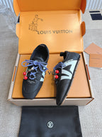 Louis Vuitton unisex sneakers in black leather with blue laces, red charms, and white V