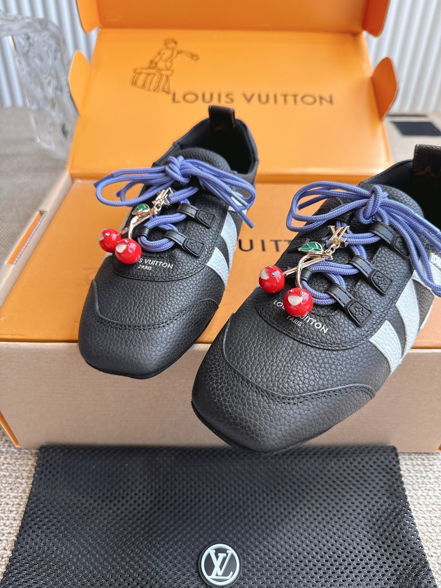 Louis Vuitton unisex sneakers in black leather with blue laces and dangling red charms