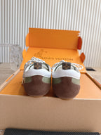 Back view of low-top sneakers, white heel tabs, olive uppers with brown soles.