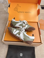 Low-top sneakers, olive and brown leather, white laces with charm and ribbon detail.