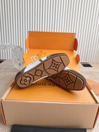 Low-top sneaker outsoles, patterned tread sole with Louis Vuitton branding in view.
