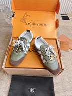 Pair of low-top sneakers, olive uppers with brown panels, white lace bows.