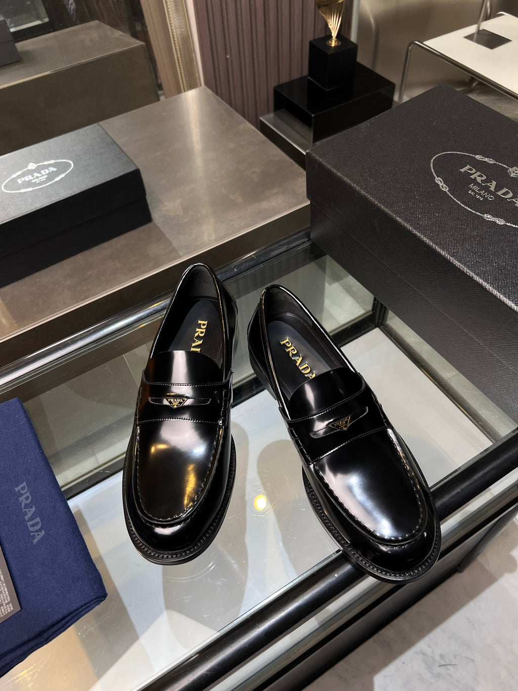Pair of glossy black loafers with gold-tone chain trim and low heel