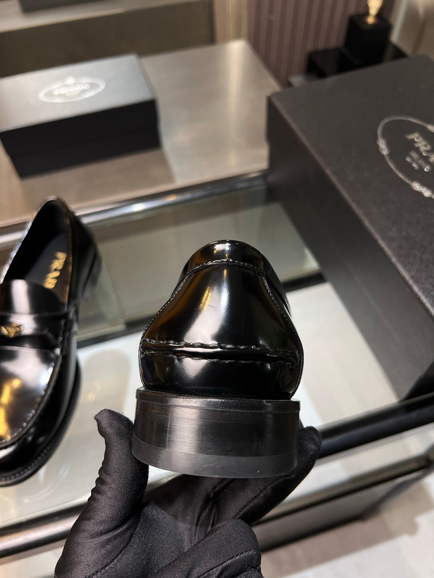 Prada unisex shoes: black patent leather loafer heel view with stacked sole