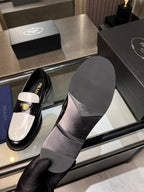 Prada loafers with black upper and white panels; visible rubber sole and heel.