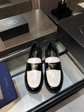 Black and white Prada loafers with gold logo, patent leather slip-on shoes.