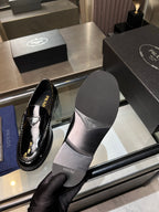 Prada unisex patent loafers, black with outsole visible and side profile