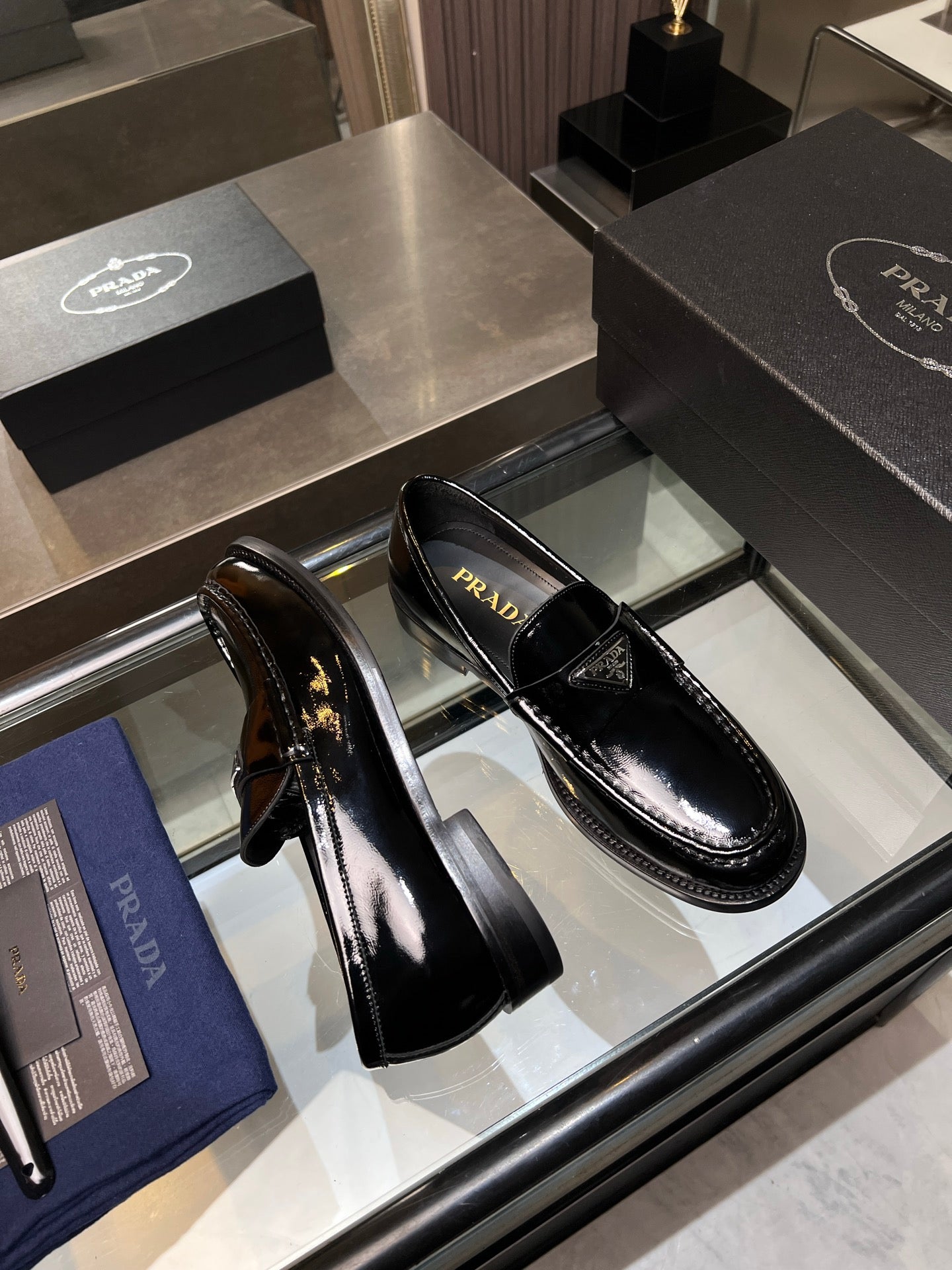 Prada unisex patent loafers, black slip-ons shown side view