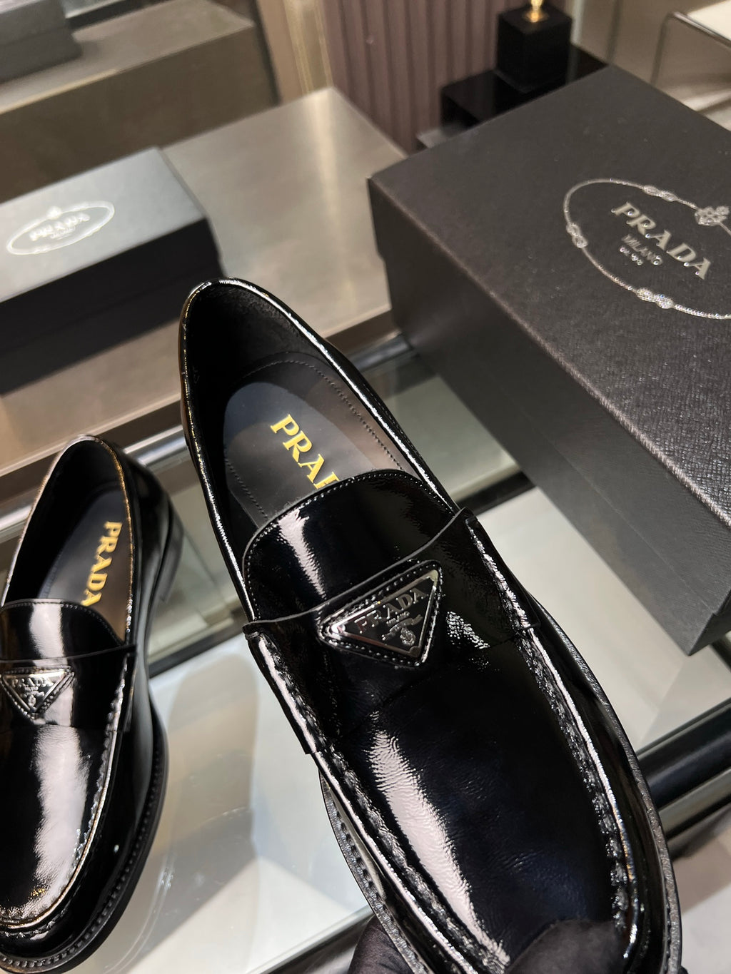 Prada unisex patent loafers, black front view with PRADA logo on insole