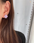 Lilac clover stud earrings on the ear with enamel petals and small clear stones