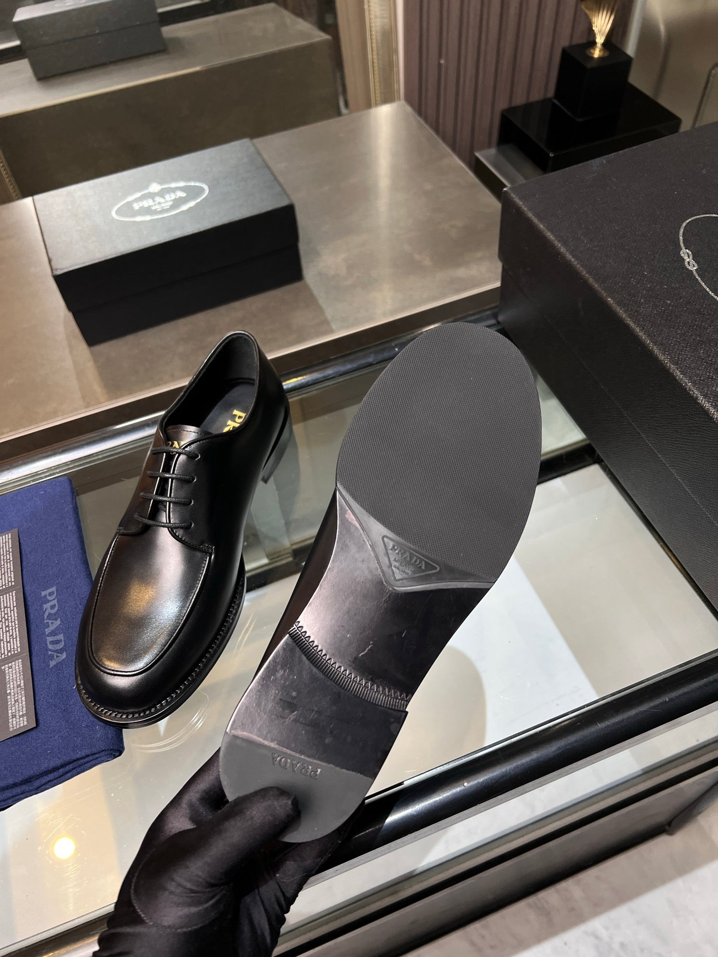 Black leather oxford shoes with lace-up front, showing inner sole and stitching