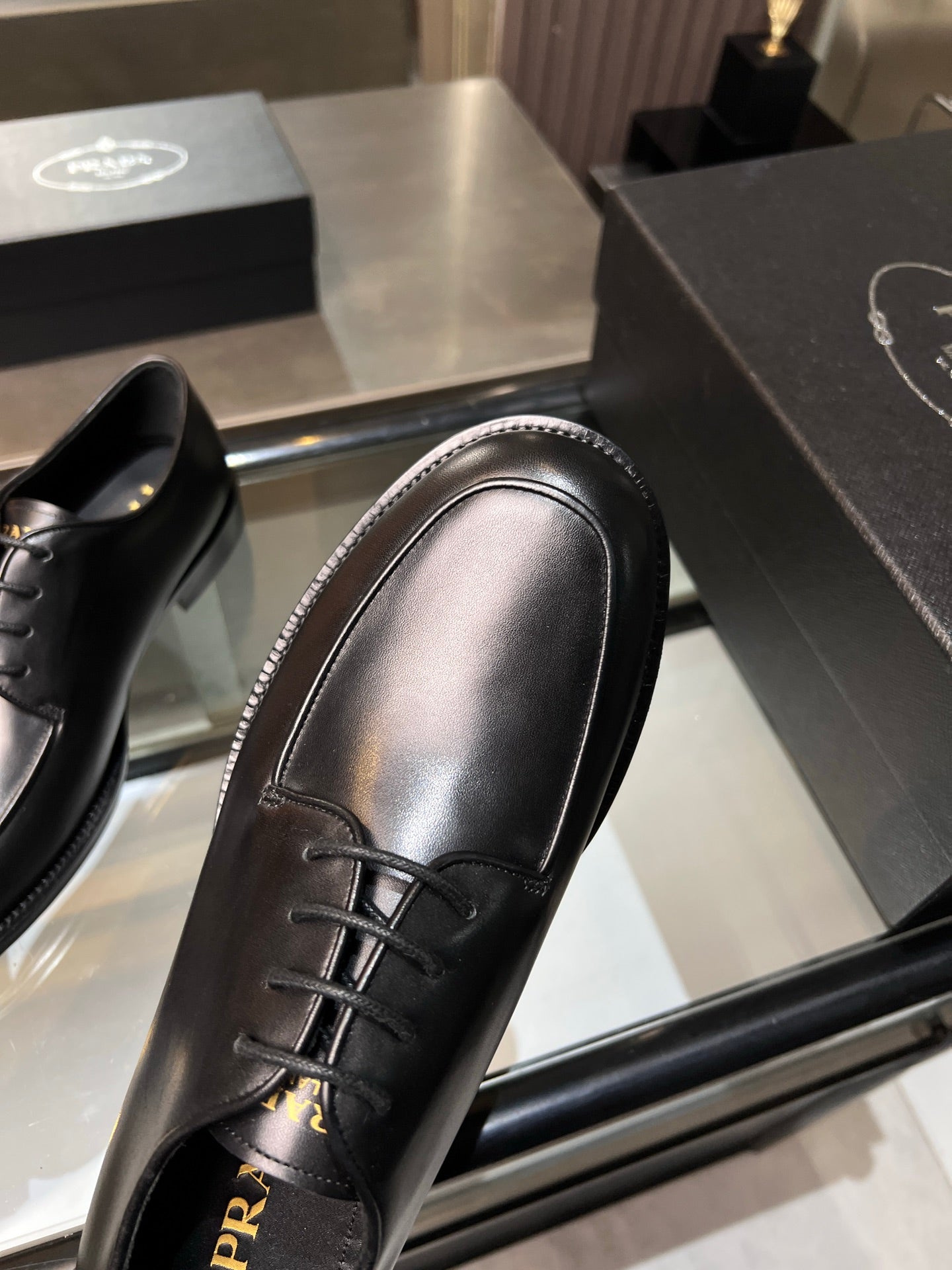 Black leather oxford shoe close-up with lace-up front and smooth rounded toe