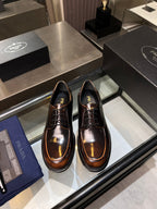 Pair of lace-up oxford shoes in dark brown polished leather, with Prada logo on tongue