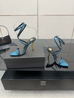 Pair of blue strappy high-heel sandals with thin ankle straps and pointed toes