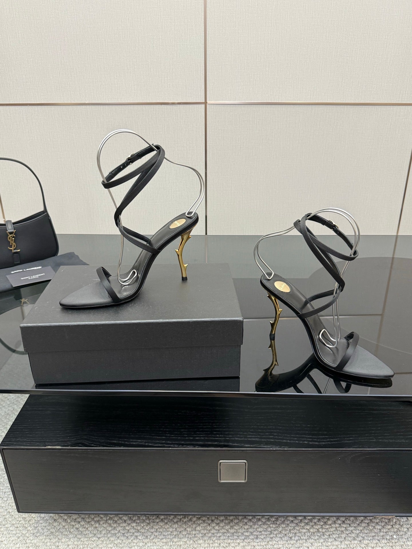 Black strappy heeled sandals with gold-tone stiletto heel and clear-style toe straps