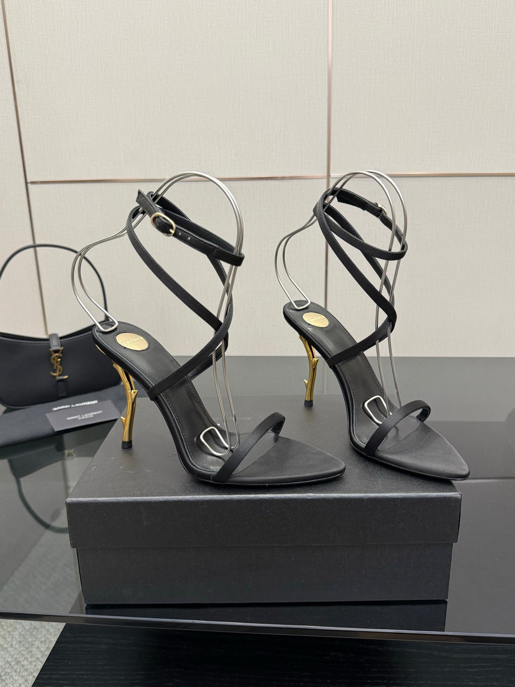 Black strappy heeled sandals with gold-tone stiletto heel and ankle wrap