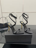 Black strappy heeled sandals with gold-tone stiletto heel and ankle wrap