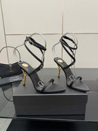 Black strappy heeled sandals with gold-tone stiletto heel and ankle wrap