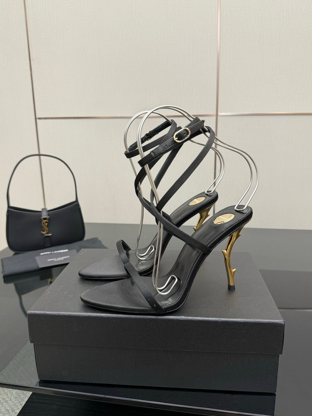 Black strappy heeled sandals with silver toe straps and gold-tone stiletto heels