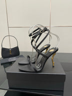 Black strappy heeled sandals with silver toe straps and gold-tone stiletto heels