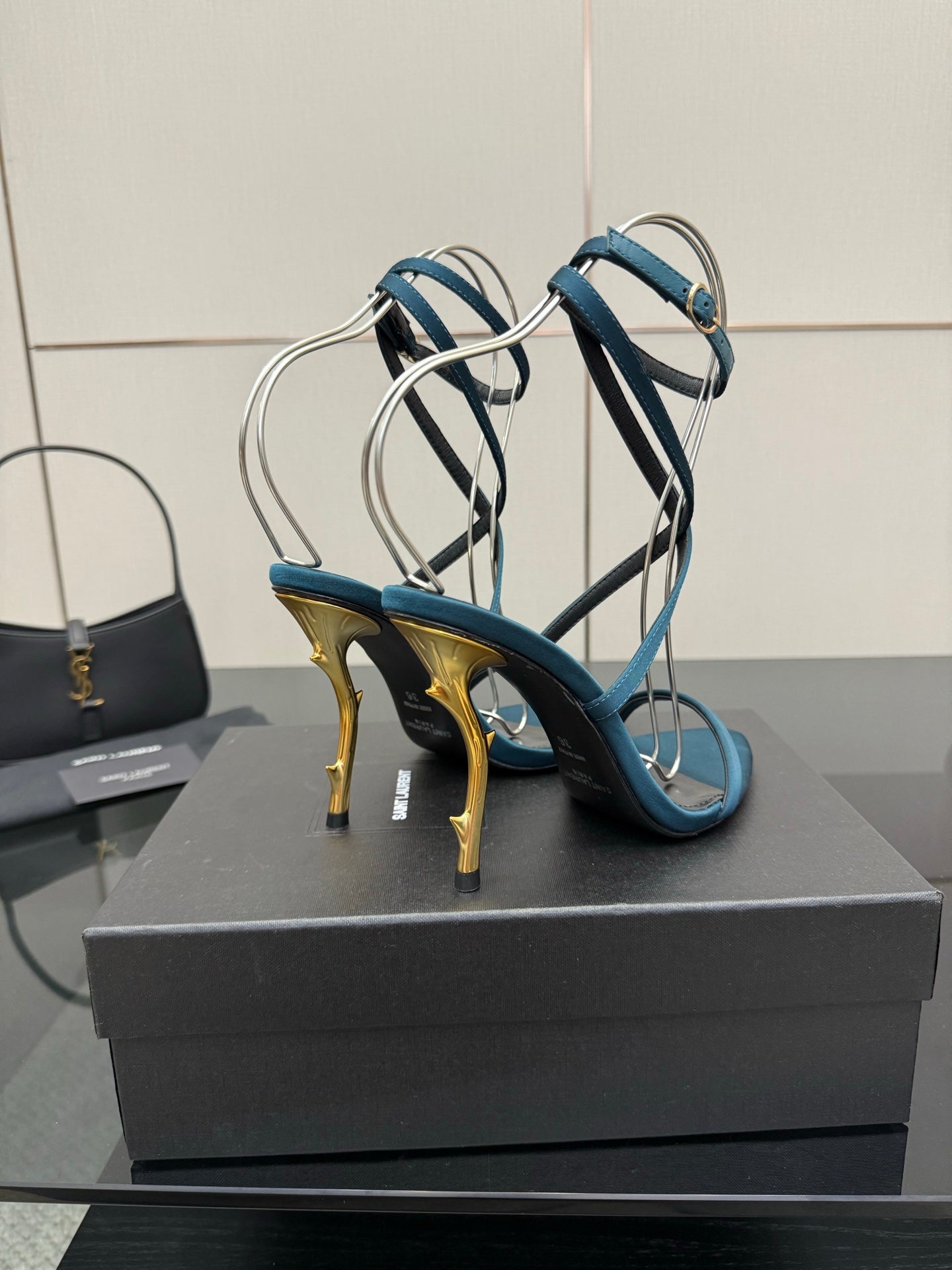 Blue open-toe strappy sandals with gold stiletto heel and crisscross straps
