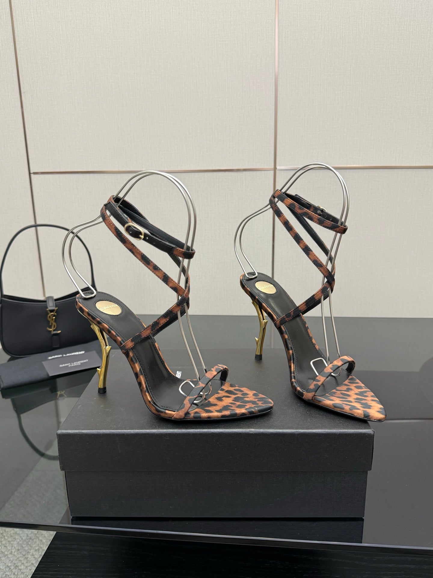 YSL women’s leopard-print heeled sandals with thin black straps and gold-tone stiletto heels